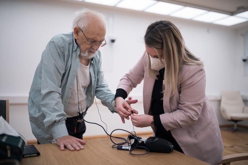 BamLiD-Mitarbeiterin Isabelle Lindner (r.) stattet einen Probanden testweise mit einem tragbaren EKG-Gerät aus.