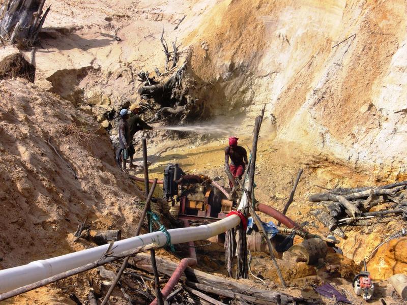 Arbeiter im Amazonasgebiet von Guayana pumpen goldhaltigen Schlamm aus einsturzgefährdeten, staubigen Minengruben.