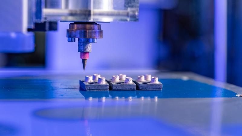 In einem Labor der Professur Elektrische Energiewandlungssysteme und Antriebe der TU Chemnitz werden beim 3D-Druck von Gehäusen für leistungselektronische Bauelemente keramische und metallische Pasten genutzt, um die Bauteilgeometrie zu erzeugen.