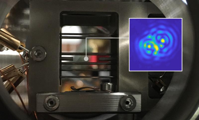 Die Ionenfalle, mit der ein einzelnes Nanoteilchen zum Schweben gebracht wird. Kleines Bild: optische Interferenz zwischen dem Teilchen und seinem Spiegelbild. 