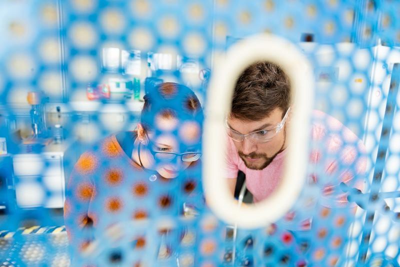 Symbolfoto: Eine Schülerin und ein Schüler nehmen im Labor an Experimenten teil. 