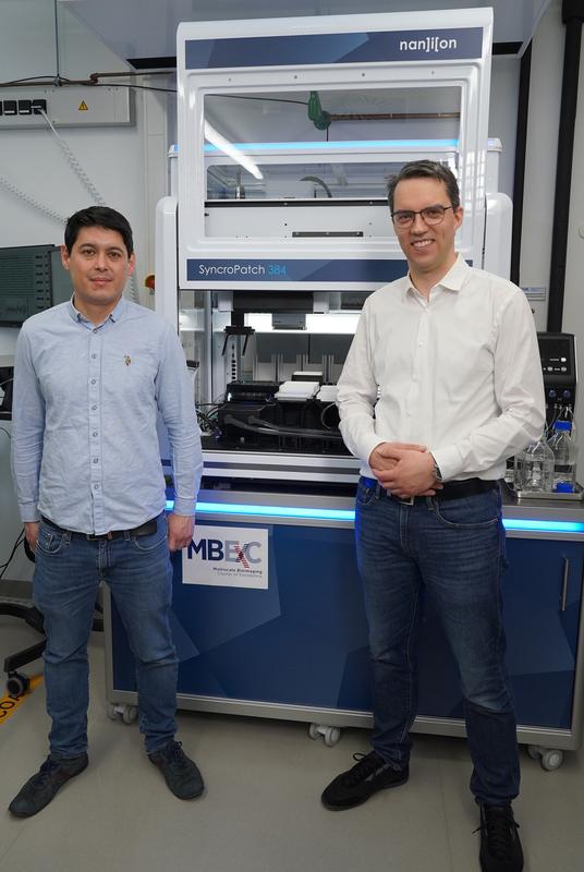 Leiter der neuen Elektrophysiologie- und Optogenetik-Plattform Prof. Dr. Niels Voigt (rechts) und Dr. Thomas Mager (links) vor dem neuen Patch-Clamp-Roboter Nanion Syncropatch 384. 