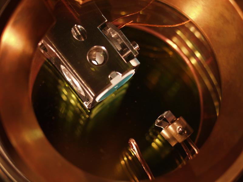 Aufbau des optischen Resonators im Vakuum. Zwischen den konisch geformten Spiegeln im Innern des Halters wird ein einzelnes Rubidiumatom gefangen.