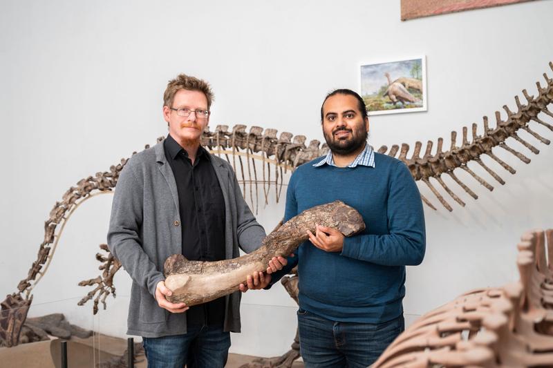 Ingmar Werneburg (links) und Omar Rafael Regalado Fernandez (rechts) halten einen Oberschenkel des Tuebingosaurus maierfritzorum. 