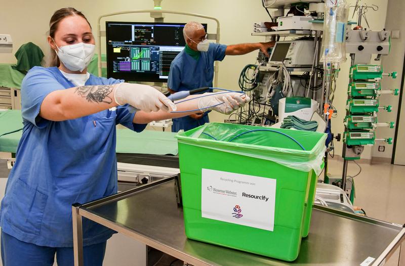 Ab in die Tonne: Danielle Gerfen, Pflegefachfrau im Herzkatheterlabor, gibt die nicht mehr benötigten Kathetermaterialien nach erfolgter Wischdesinfektion in den grünen Sammelbehälter