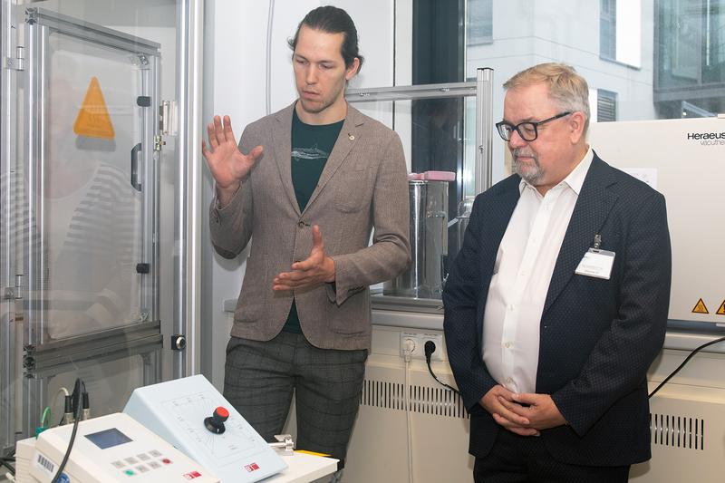 Dr. Michael Poschmann (stellv. Projektkoordinator bei dem TransHyDE-Projekt AmmoRef und Postdoc am MPI CEC) erklärt Jens Geier (MdEP) die Katalysatorsynthese zur Ammoniak-Reformierung. 