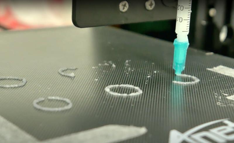 Der selbstgebaute 3D-Drucker des Teams bei einem der ersten Drucktests mit Tinte verschiedener Konsistenzen. 