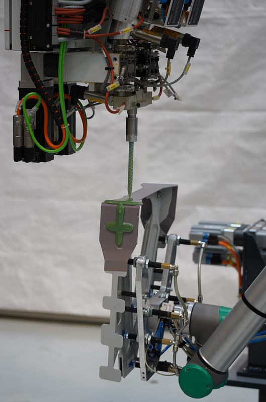 Automated rudder hinge assembly in aircraft tail planes – Automated on-demand shim application to compensate component tolerances: a lightweight robot guides a rudder hinge under the dispensing system for liquid shim application