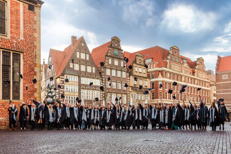 Absolvent:innen der APOLLON Hochschule feiern ihre Studienabschlüsse 2022 mit dem traditionellen Hütewerfen.