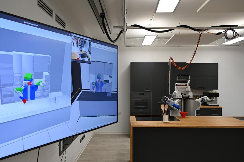 A robot helps out in the kitchen: a scene from the new robotics lab at the University of Bremen. 