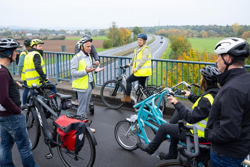 Bei der Radtour zum Kick-off erläutert h_da-Mobilitätsforscher Prof. Dr. Jürgen Follmann die Idee hinter dem Radweg der Wissenschaften (Bildmitte, mit gelber Weste)