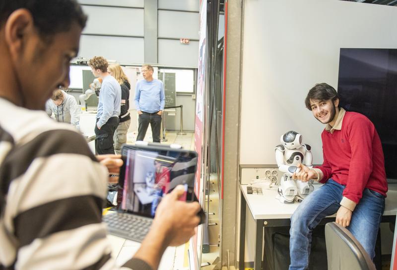 Erinnerungsfoto mit einem Roboter am Lehrstuhl Automatisierungstechnik. 