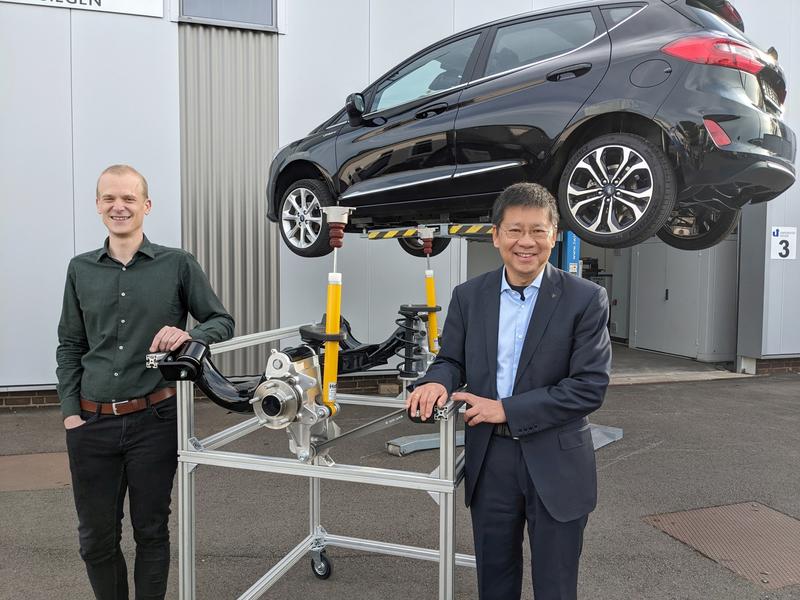 Jens Olschewski und Prof. Dr.-Ing. Xiangfan Fang mit dem Prototyp der neuartigen Hinterachse und dem Testwagen von Ford.