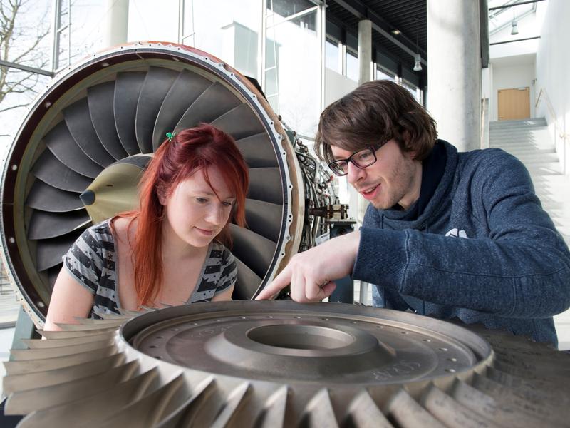 BTU-Studierende an einem Flugzeugtriebwerk.