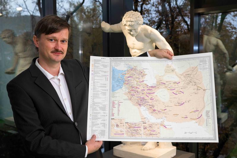 Der Jenaer Althistoriker Dr. Frank Schleicher mit einer Landkarte des sasanidischen Iran.