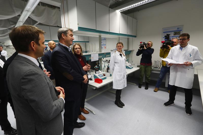 Ministerpräsident Dr. Markus Söder (3. v. l.) macht sich vor Ort ein Bild von den Arbeiten am BayBatt, Universitätskanzlerin Dr. Nicole Kaiser (rechts daneben) erläutert Details zum BayBatt.  