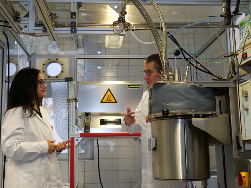 Frau Dr. Ajarroud (UCB) und Herr Bettinger (Neveon) am Reaktor für hydrothermalen Karbonisierung.