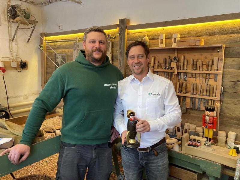 Kunsthandwerker Markus Füchtner (links) und Holger Kunze (Fraunhofer IWU) mit der innovativen Räucherrakete aus Seiffen