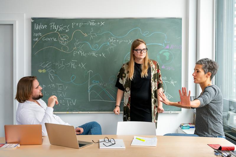 Prof. Dr. Laura Fabbietti (rechts) diskutiert mit Laura Šerkšnytė (Mitte) und Stephan Königstorfer über die Experimente zur Antihelium-3-Wechselwirkung. 