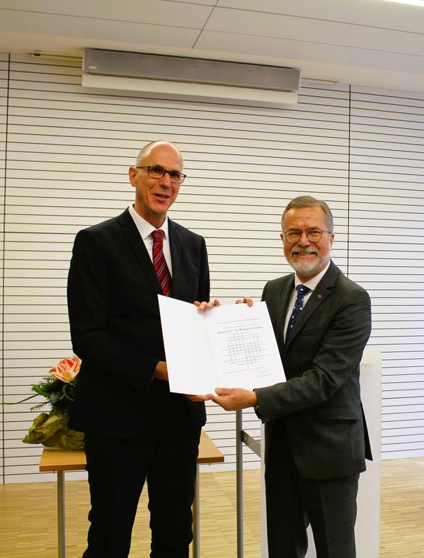 Hochschulpräsident Prof. Dr. Gunther Piller (links) überreicht die Urkunde an Ehrensenator Prof. Dr. Wolfgang Anders. (Bild: HWG LU) 