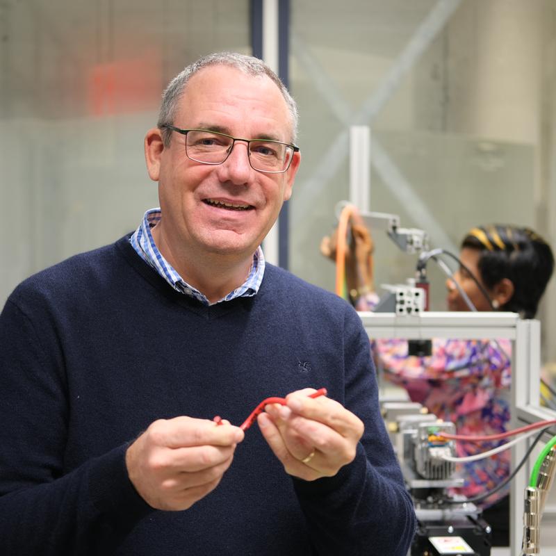 Professor Stefan Diebels und sein Team führen umfangreiche experimentelle Untersuchungen an unterschiedlichen Kabelproben durch. Im Hintergrund arbeitet Doktorandin Carole Tsegouog an einem Versuchsstand.