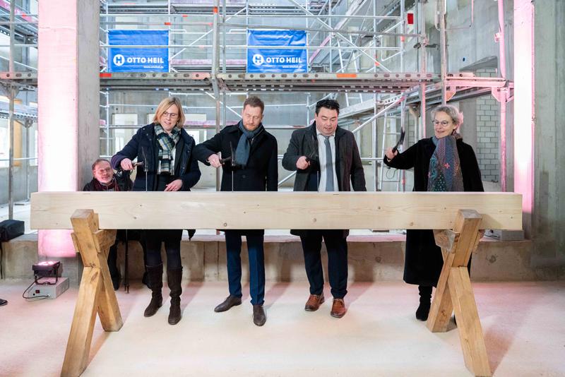 Prof. Esther Troost, Dekanin der Medizinischen Fakultät; Ministerpräsident Michael Kretschmer; Frank Ohi, Kaufmännischer Vorstand des Dresdner Uniklinikums und Prof. Ursula Staudinger, Rektorin der TU Dresden schlagen die Nägel in den Balken.