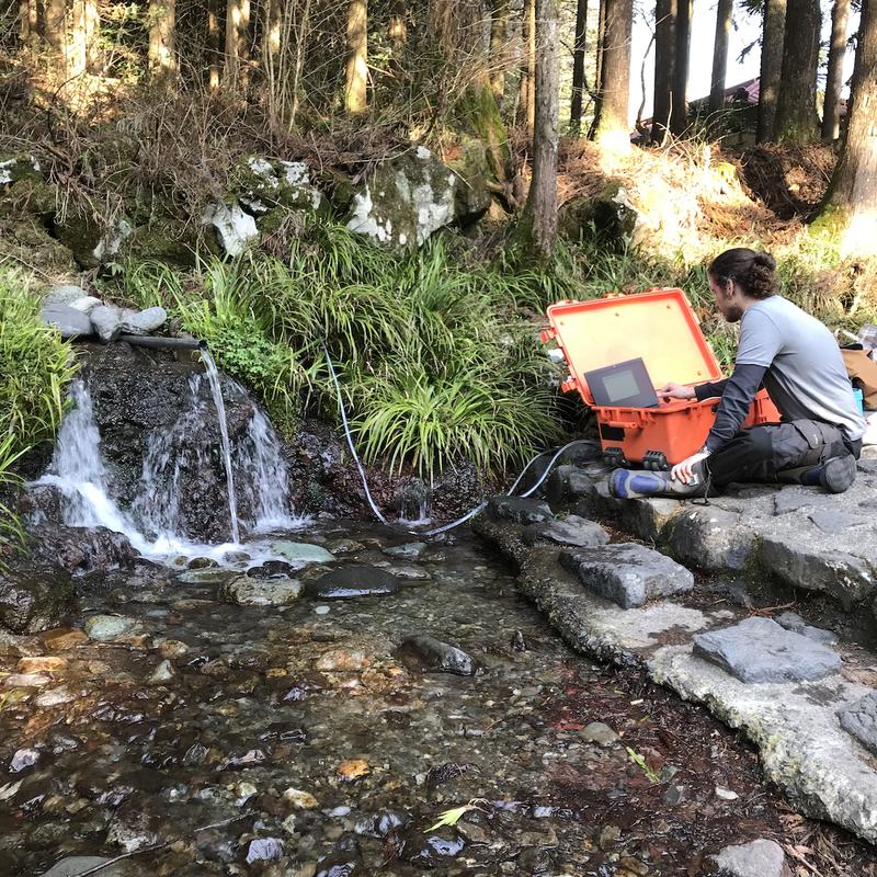 Oliver Schilling analyzing spring water at Mount Fuji.