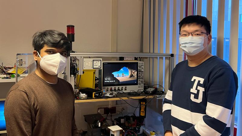 Madhu Lakshman Mysore (left) and Xing Liu, research associates at the Professorship of Power Electronics at Chemnitz University of Technology and researchers in the "Power2Power" project, at the test stand for power semiconductors.