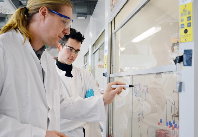 Professor Manuel van Gemmeren (l.), hat mit seinem Forschungsteam, darunter Doktorand Fritz Deufel (r.), eine Methode entwickelt, mit der sich bisher schwer zugängliche chemische Verbindungen leichter herstellen lassen.