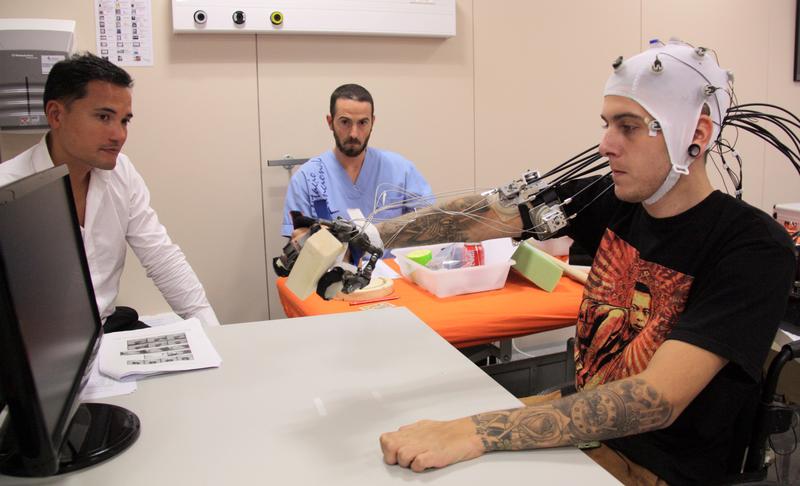 Patient testing a brain-computer interface developed by Charité to control an exoskeleton hand.