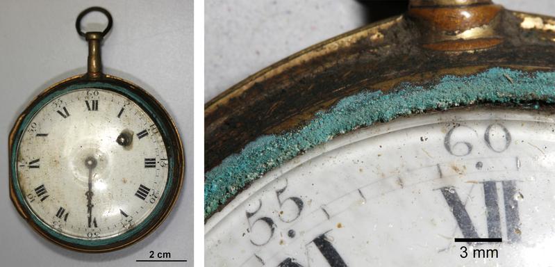 Instabiles Glas bewirkt Kontaktkorrosion am Messinggehäuse einer Uhr: Durch Formaldehyd aus Holzwerkstoffen entstehen Formiate des Kupfers (grün) und des Zinks (weiß).