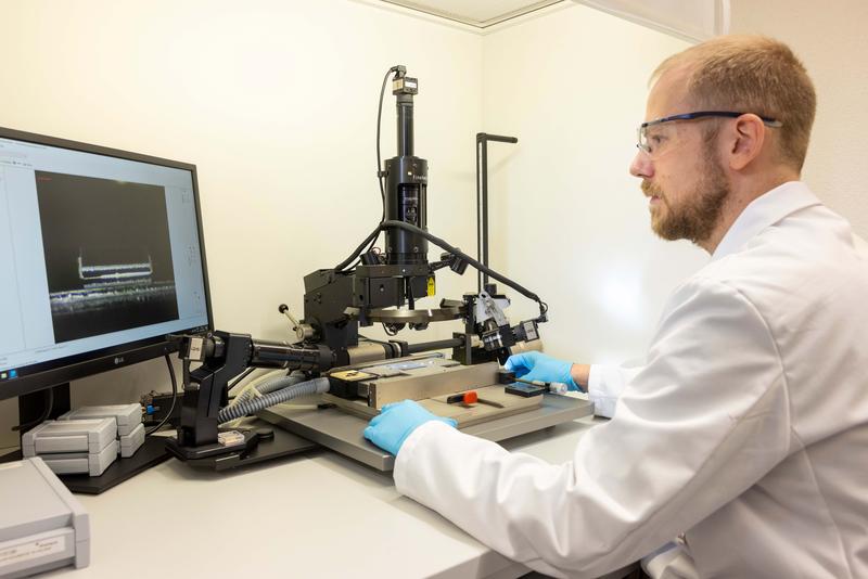 Genauigkeit: Bastian Rheingans inspiziert an einem Flip-Chip-Bonder einen Chip, der mikrometergenau auf ein Trägersubstrat gefügt wurde.