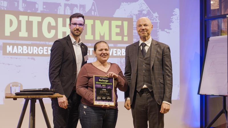 Nicole Paczia und David Adam vom Gewinnerteam HAPPY. Ihre Gründungsidee entstand am Marburger Max-Planck-Institut für terrestrische Mikrobiologie. Mit ihnen freute sich Staatssekretär Dr. Philipp Nimmermann vom Hessischen Wirtschaftsministerium (rechts).