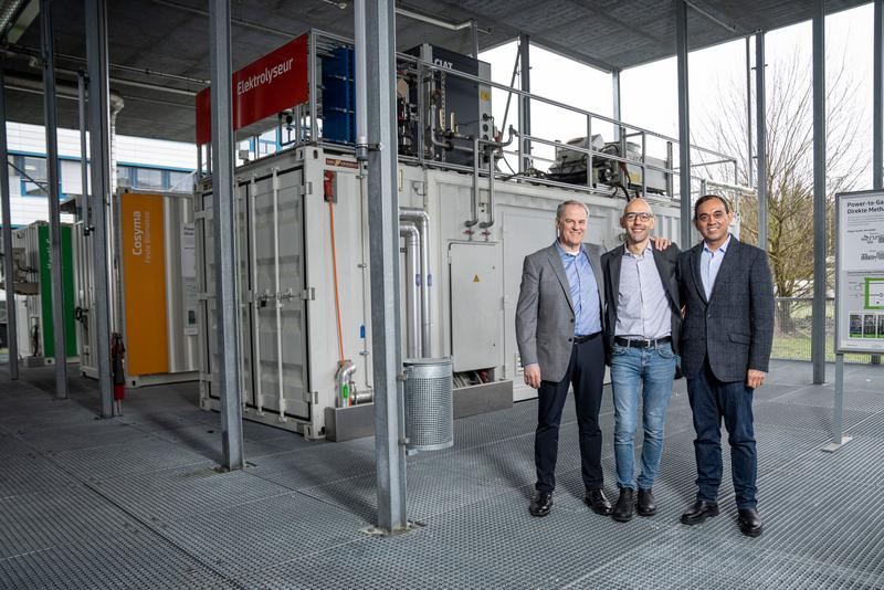 Leigh Hackett (links) und Saurabh Kapoor (rechts) von Metafuels und Marco Ranocchiari vom PSI (Mitte) auf der ESI-Plattform. Hier entsteht eine neue Pilotanlage aus zwei Container-Modulen, um synthetisches Kerosin aus erneuerbaren Ressourcen herzustellen.