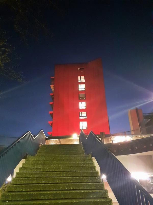 „Shine a light on encephalitis“ – es zeigt das Hauptgebäude der MHH, das in rot erstrahlt.