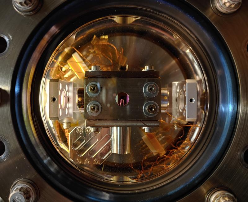 Die Vakuumkammer mit dem Versuchsaufbau. Der Resonator besteht aus zwei Spiegeln, die so beschichtet sind, dass sie infrarotes Licht extrem reflektieren. An der Spitze des zylindrischen Teils in der Mitte sitzt eine Linse.