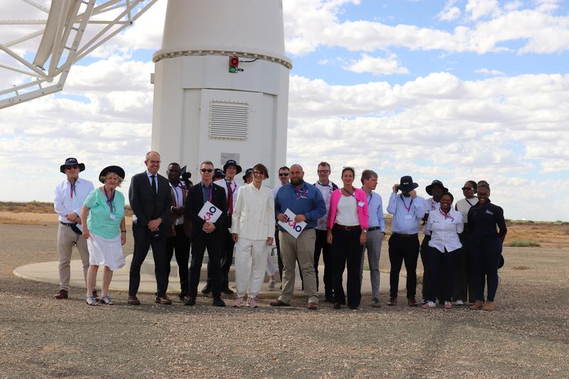 Group photo at the base of the SKA-Max Planck Dish Demonstrator in the Karoo region of South Africa. In the center: Federal Research Minister Bettina Stark-Watzinger with Michael Kramer/MPIfR (left) and Lindsay Magnus/SARAO (right).