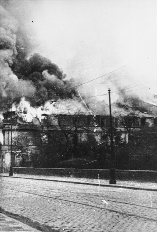 A building razed by the SS burns during the suppression of the Warsaw ghetto uprising., Warsaw 19 April–16 May 1943.