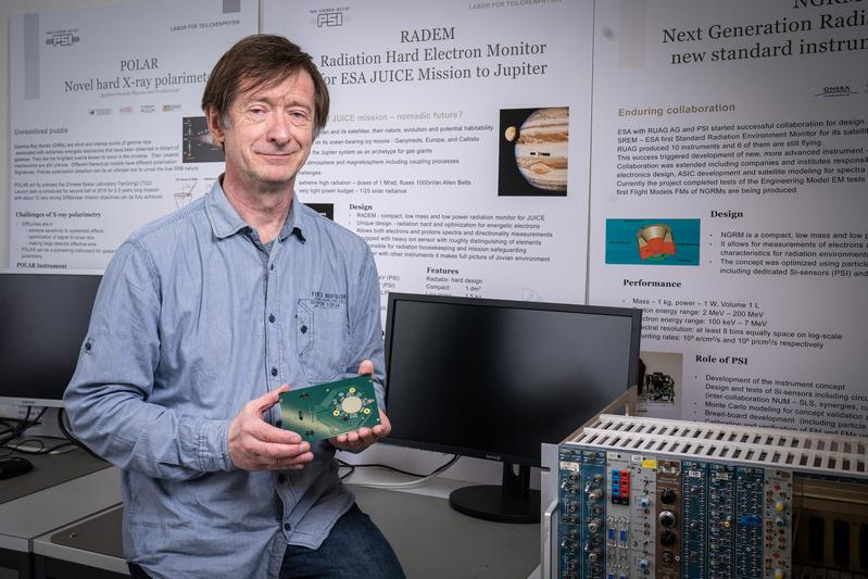 Wojciech Hajdas mit einem Prototyp des unverkleideten Richtungsdetektors. Eine solch kompakte Leiterplatine ist in RADEM verbaut und detektiert die Einfallsrichtung von Elektronen und Protonen. 