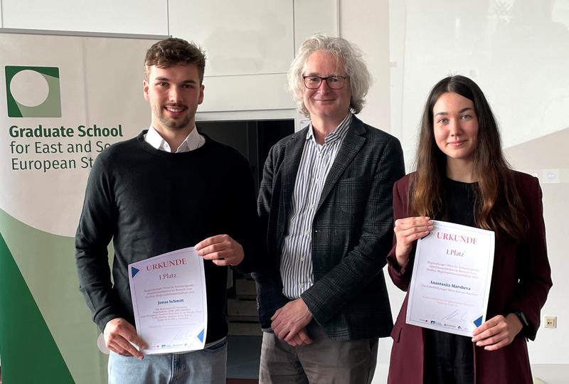 Der Sprecher der Graduiertenschule für Ost- und Südosteuropastudien, Prof. Dr. Ulf Brunnbauer (M.), zeichnete Jonas Schmitt (l.) und Anastasiia Marsheva (r.) mit dem Regensburger Area-Studies-Preis aus. 