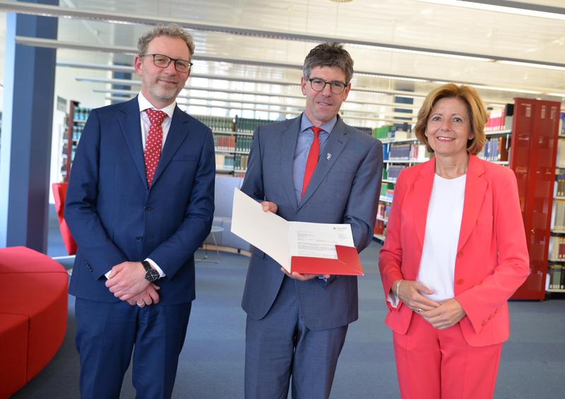 Ministerpräsidentin Malu Dreyer übergab in der Universitätsbibliothek den Förderbescheid an Michael Jäckel (Universitätspräsident) und Andreas Regelsberger (Dekan des Fachbereichs II). 