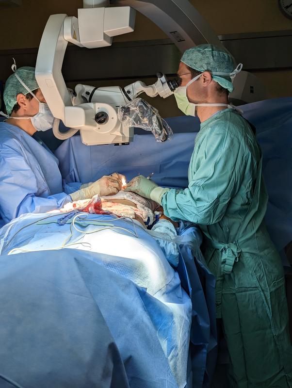 Unter dem Operationsmikroskop führen die Plastischen Chirurgen die mikrochirurgische Blutgefäßnaht zur Durchblutung der neuen Brust durch. 