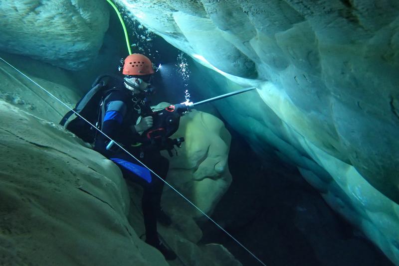 A diver takes cores from the cave wall with a drill.  Using an underwater drill specially developed for the expedition to Devils Hole, the researchers took samples from the calcite deposits in the cave.