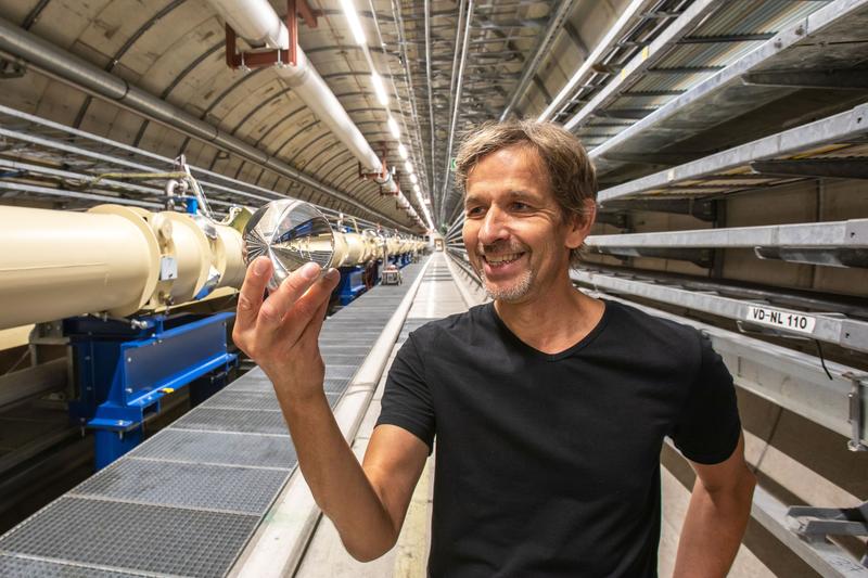 ALPS-Sprecher Axel Lindner (DESY) mit einer Glaskugel vor der Magnetreihe des ALPS-Experiments im HERA-Tunnel. 