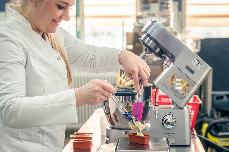 Doctoral candidate Natalie Feller portions the bread dough with alternative proteins instead of gluten into the mini loaf pans for the baking line 30g at a time.