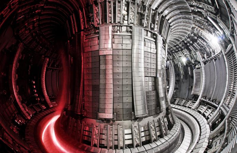 Plasmagefäß des Experiments JET in Culham. Links ist ein brennendes Plasma zu sehen. Die „Rinne“ unten im Reaktorgefäß ist der „Divertor“. Prof. Brezinsek erforschte, wie der Beschuss mit hochenergetischen Wasserstoffionen v.a. auf Wandmaterialien wirkt.