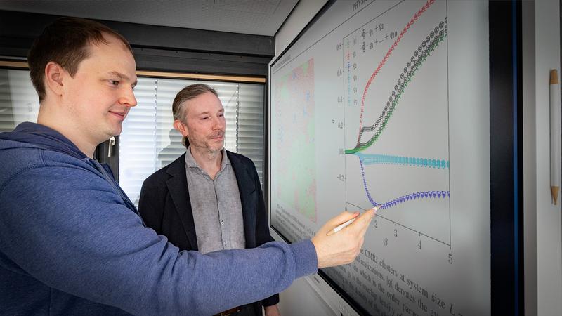 Lambert Münster (l.) und Prof. Dr. Martin Weigel von der Professur Simulation naturwissenschaftlicher Prozesse der TU Chemnitz betrachten am Bildschirm Kurvenverläufe, welche die Überlappung von Netzwerken in Spingläsern beschreiben. Foto: Jacob Müller