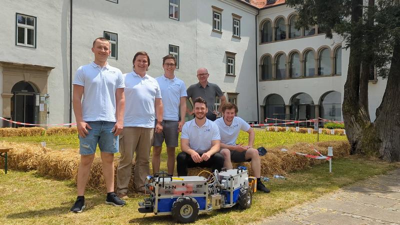 Das Team FloriBot (v.l.n.r.): Klaudius König, Benedict Bauer, Paul Wolff und Professor Torsten Heverhagen mit Marcel Holzwarth und Martin Haag (vorne sitzend, v.l.n.r) 