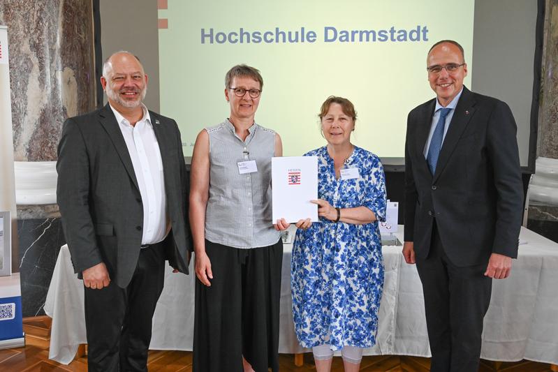 Hessens Innenminister Peter Beuth (rechts) übergibt die Gütesiegel-Urkunde an h_da-Präsident Prof. Dr. Arnd Steinmetz (links), Familienbüro-Leiterin Ulrike Amann (Mitte) und Gabriele Jung, Zertifikate Familienfreundlichkeit (daneben).
