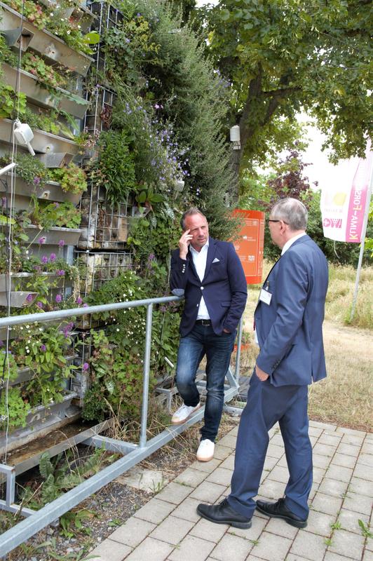 (v.l.n.r.) Staatsminister Thorsten Glauber, MdL im Gespräch mit CAE-Geschäftsführender Vorstandsvorsitzender Dr. Hans-Peter Ebert) über innovativer Konzepte zur Fassadenbegrünung.